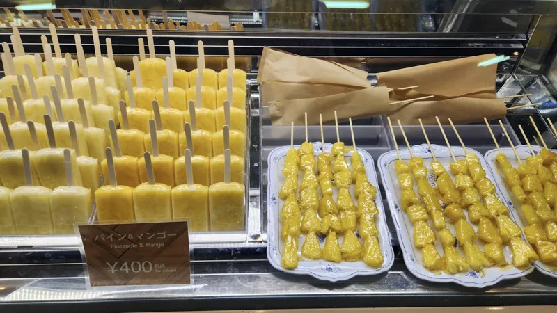 Pineapple popsicles and pineapple skewers displayed in a shop in Okinawa