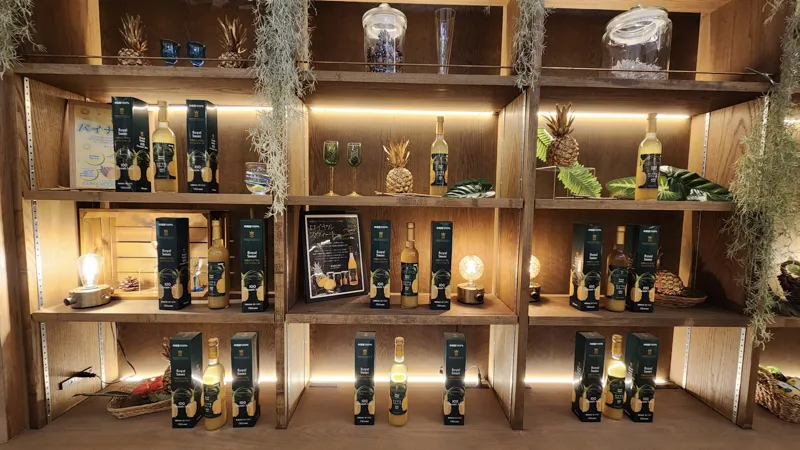 Bottles and pineapple themed products displayed on wooden shelves