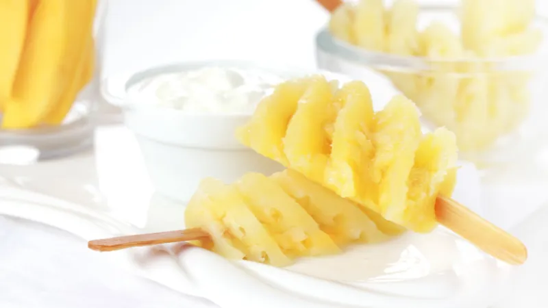 Fresh pineapple sliced in a spiral on a wooden stick