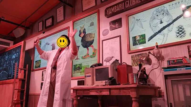 Performer presenting the Yambaru Friends show inside a themed laboratory at Junglia Okinawa