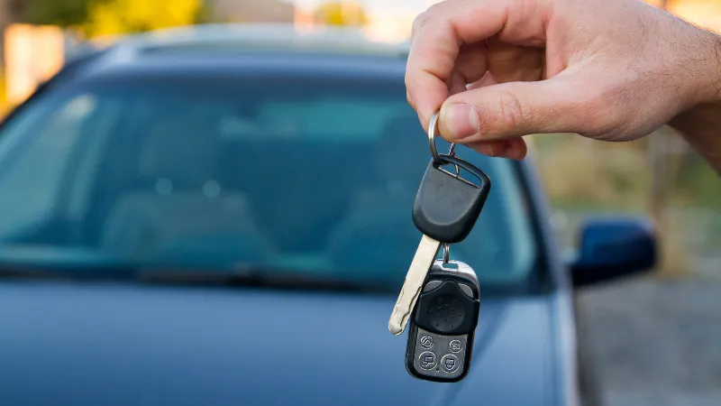 Car keys held in front of a parked car near Yoshinoura Park in Okinawa