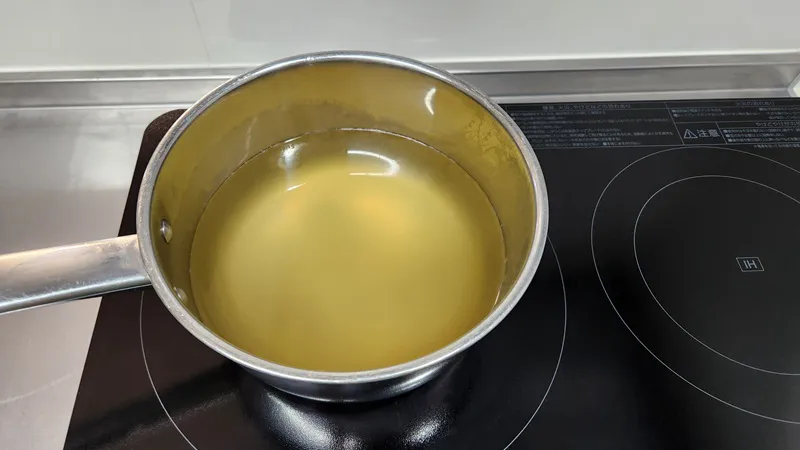 熱湯で下茹でされている鶏肉。
鍋に入った澄んだ鰹だし。
