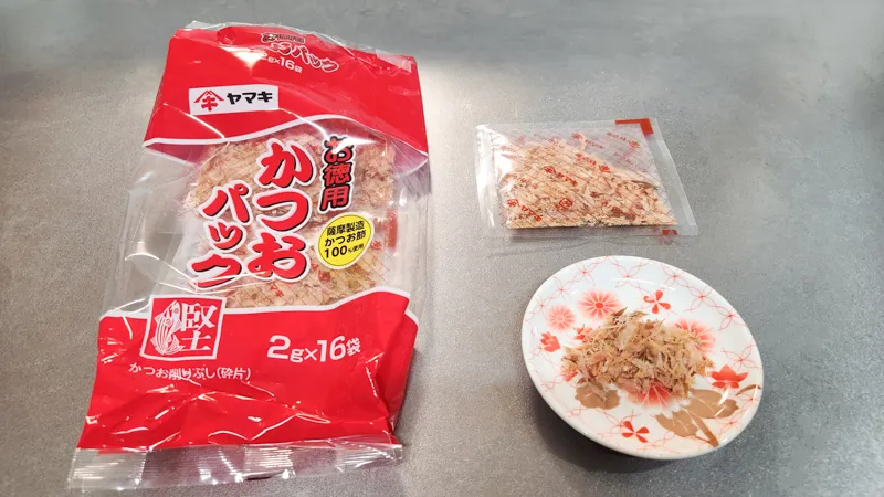 Packaged katsuobushi bonito flakes with a small portion prepared on a plate
