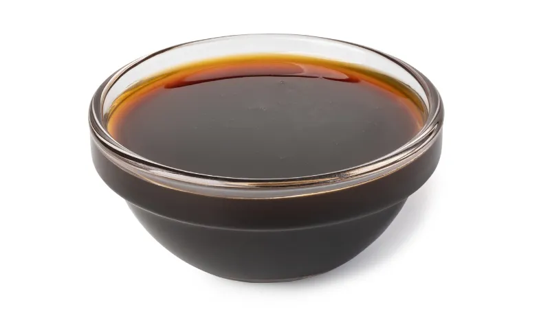 Dark soy sauce served in a small glass bowl