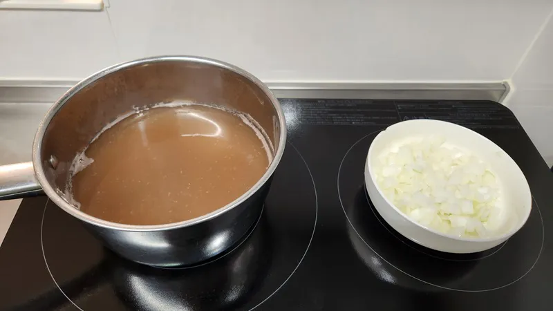 角切りの玉ねぎと一緒に静かに煮ている軽い鰹だし。
