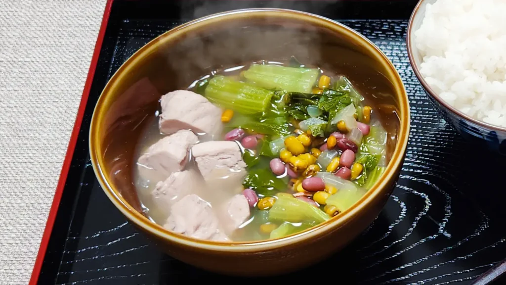 Bowl of Japanese chicken soup with vegetables and beans served with white rice