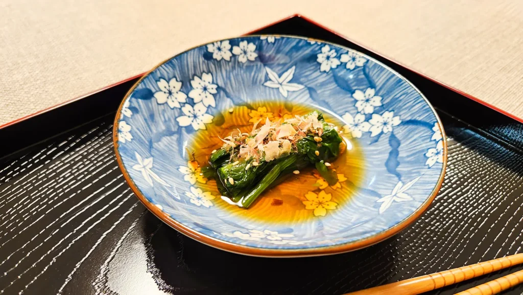 Close-up of Japanese spinach salad with bonito flakes and sesame seeds