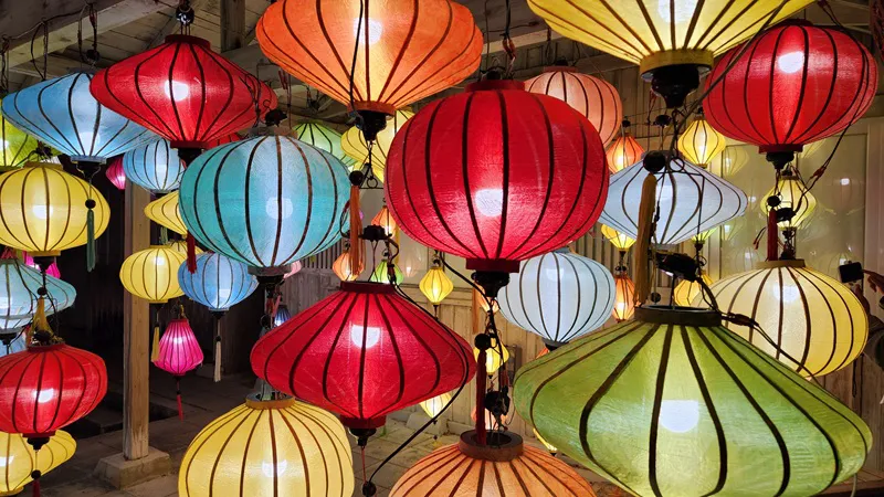 Colorful paper lanterns hanging closely together at night