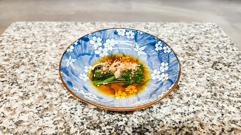 Japanese spinach salad topped with bonito flakes and sesame seeds
