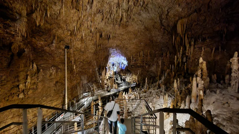 Family exploring the spacious interior of a limestone cave in Okinawa World