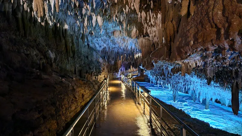 Path through a cave lined with stalactites and glowing reflections