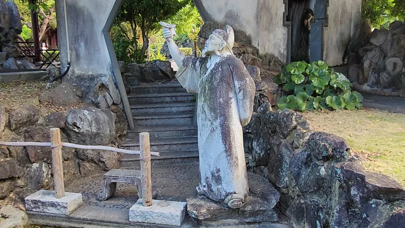 Stone statue of a scholar holding a scroll in chinese Garden Okinawa