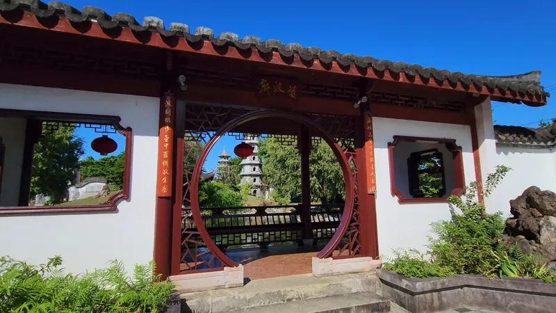Circular moon gate entrance with traditional Chinese architecture in Fukushuen Garden Okinawa
