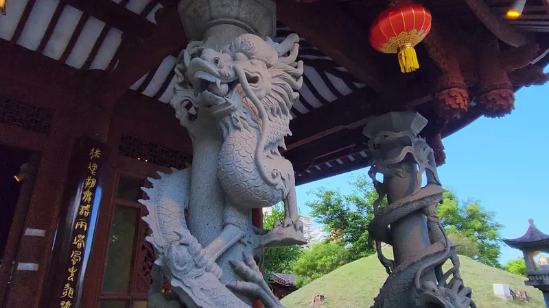 Carved stone dragon pillars supporting a pavilion roof in Fukushuen chinese Garden Okinawa