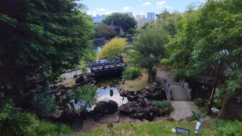 Panoramic view of garden paths, pond, and stone bridges in Fukushuen Garden Okinawa