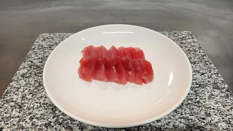 Raw bluefin tuna fillets arranged on a white plate